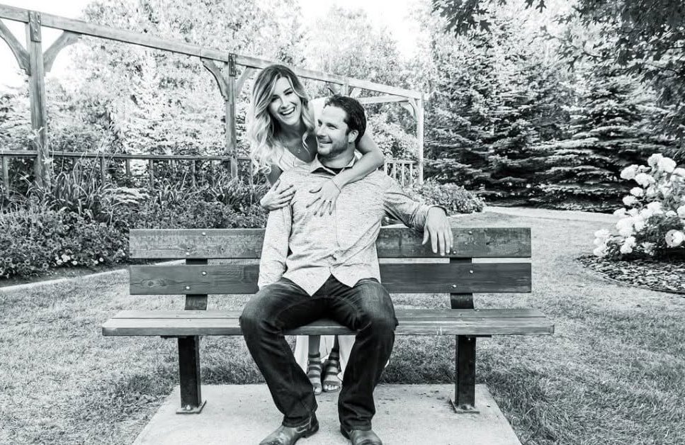 Black and white portrait of a couple laughing on a park bench